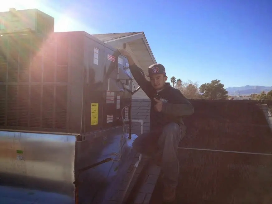 HVAC technician performing HVAC Inspection on a rooftop unit in Inverness